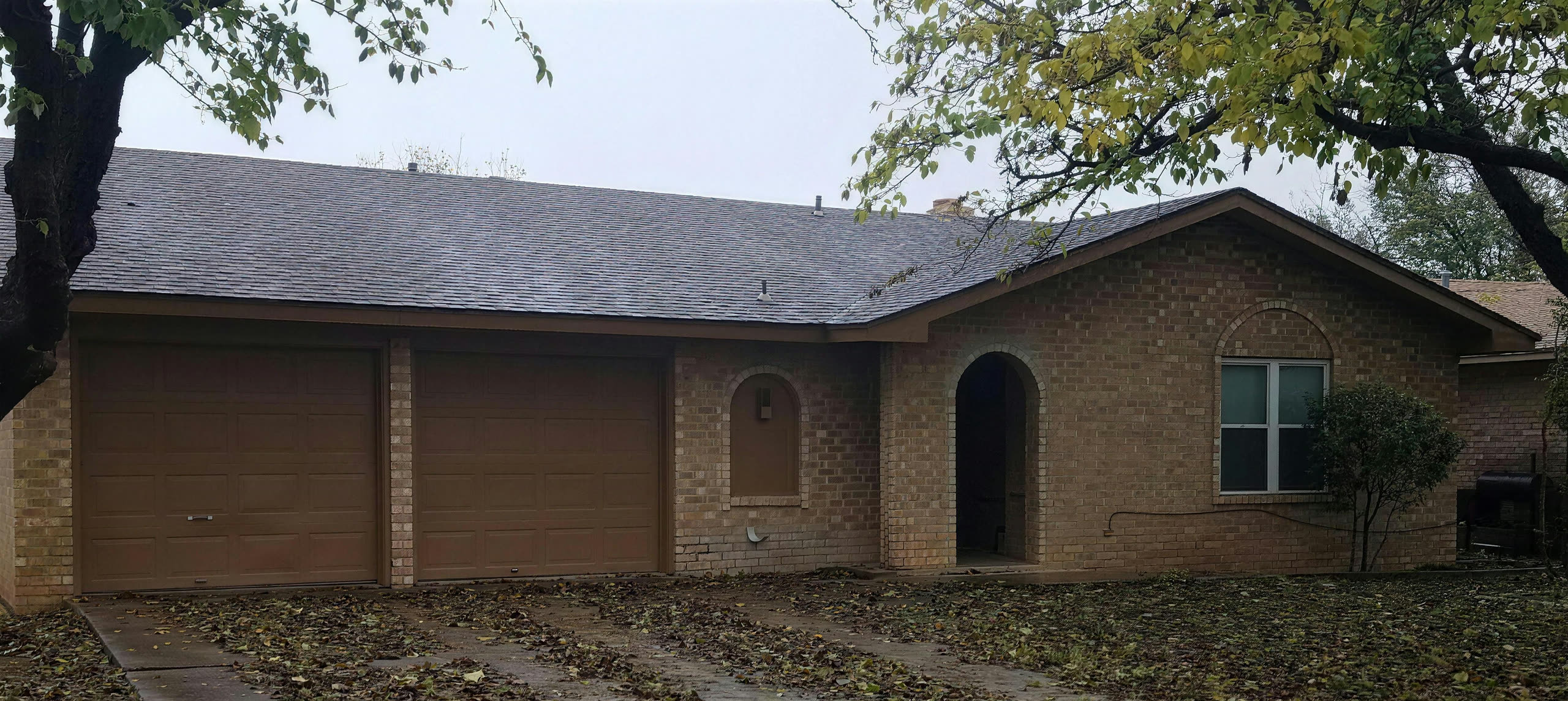 Brick ranch house with a new grey shingle roof